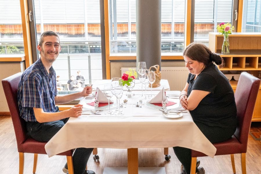 Ein Mann und eine Frau sitzen an einem gedeckten Tisch  im Restaurant