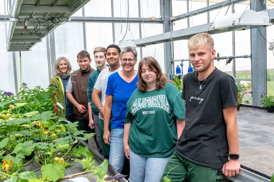 Lehrerinnen mit Schüler und Schülerinnen im Gewächshaus.