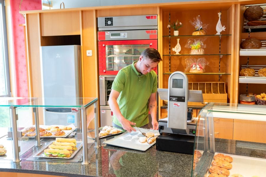 Junger Mann beim Sortieren von Backwaren