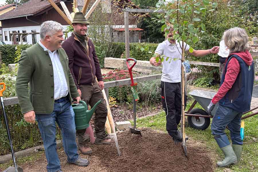 Drei Männer und eine Frau bei der Baumpflanzaktion